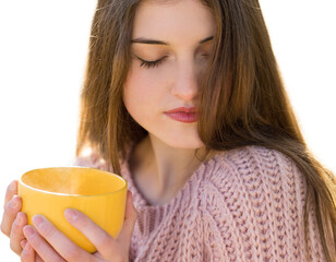 Portrait of pretty young woman in stylish knitted sweater standing with a yellow cup