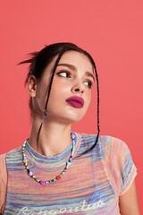 Young woman with colorful attire and bold makeup.