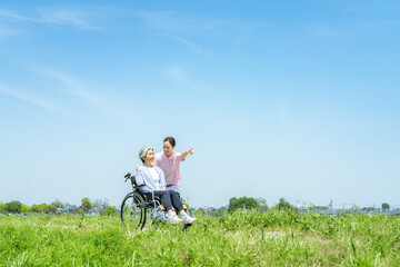 車椅子のシニアと介護士