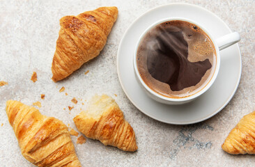 Freshly baked croissants and steaming cup of coffee creating perfect breakfast scene