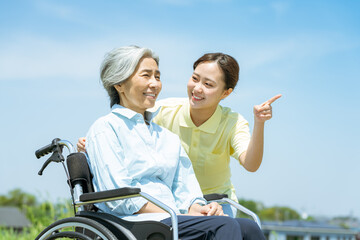 車椅子のシニアと介護士