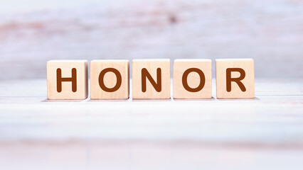 The HONOR concept word is assembled from wooden cubes. ethics, respect, code, honesty, integrity concept