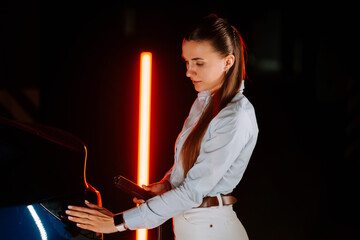 Woman charges electric car in modern underground parking lot during evening hours