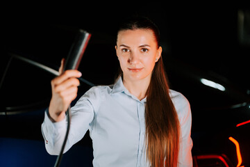 Woman charging electric car in underground parking lot during evening hours