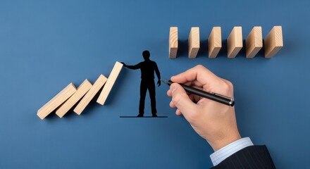 A hand with a pen stopping dominoes from falling with a drawn silhouette of a person on blue