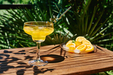 Summer refreshing orange soda drink on the table in the garden. Iced lemonade with orange slices.