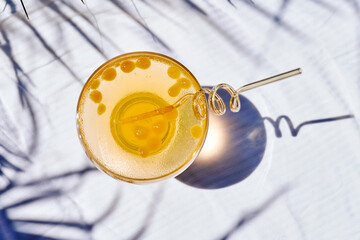 Summer refreshing orange soda drink on the table in the garden. Iced lemonade with orange slices.