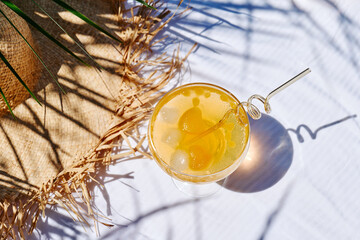 Summer refreshing orange soda drink on the table in the garden. Iced lemonade with orange slices.