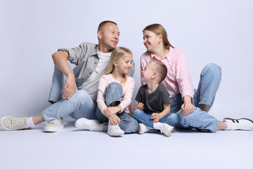 Full length portrait of happy family on light grey background