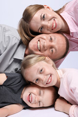 Happy family posing on light grey background