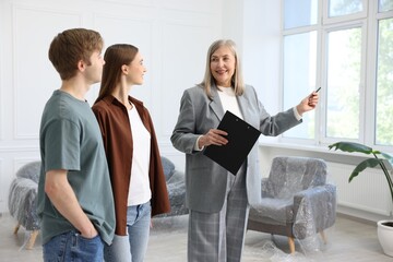 Smiling real estate agent working with couple at home