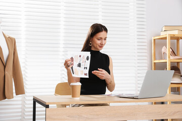 Professional stylist having online consultation with client via laptop at desk indoors