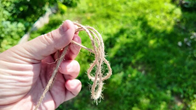scourge. Texture of Natural Jute Twine. High-resolution texture of natural jute twine, showing its rough fibers and organic weave. scourge in hand. Jute burlap rustic twine string rope cord.