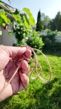 scourge. Texture of Natural Jute Twine. High-resolution texture of natural jute twine, showing its rough fibers and organic weave. scourge in hand. Jute burlap rustic twine string rope cord.