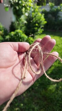 scourge. Texture of Natural Jute Twine. High-resolution texture of natural jute twine, showing its rough fibers and organic weave. scourge in hand. Jute burlap rustic twine string rope cord.