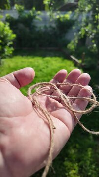 scourge. Texture of Natural Jute Twine. High-resolution texture of natural jute twine, showing its rough fibers and organic weave. scourge in hand. Jute burlap rustic twine string rope cord.