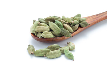 Green cardamom seeds in a wooden spoon on white background