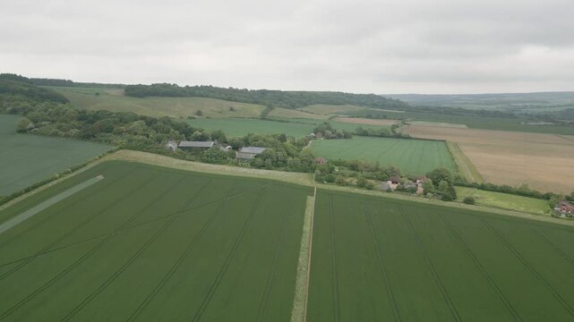 Aerial view of Kent countryside farmers fields with neat tractor lines on a cloudy day