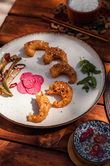 Crispy fried shrimp served with smashed cucumber salad and marinated daikon. Bright and flavorful Vietnamese dish captured in flat lay style