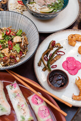 Authentic Vietnamese cuisine including pho bo, spring rolls with shrimp and noodles, fried shrimp, chicken noodles, rice, and pickled vegetables. Flat lays and styled food shots