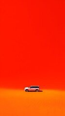 Miniature SUV driving on orange background