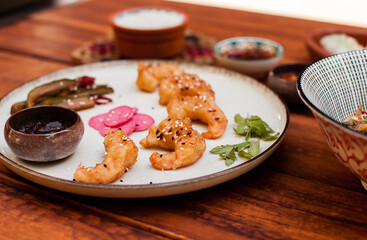 Crispy fried shrimp served with smashed cucumber salad and marinated daikon. Bright and flavorful Vietnamese dish captured in flat lay style