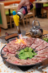 Korean BBQ with Sliced Beef and Vegetables Grilled with Torch on Hot Plate