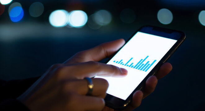 Analyzing data trends on a mobile device urban night setting smartphone usage technology insights close-up view digital analytics