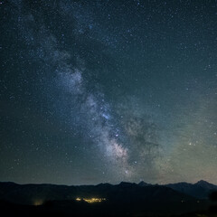 The Milky Way over the mountains of the Balagne region of Corsica with the lights of the village of Speloncato in the distance