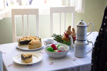 Easter table setting with traditional czech cake, colored eggs and vintage coffee pot in Kourim, Czechia