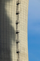 Metal stairs climbing a tall concrete cooling tower of a nuclear power plant