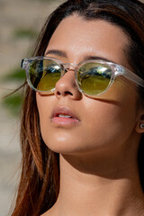 Model posing confidently in trendy sunglasses, soaking up the sun on a beautiful outdoor day, radiating style and happiness