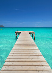 Fototapeta premium Rustic Wooden Pier Stretching Over the Blue Mediterranean Sea on a Sunny Summer Day