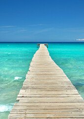 Obraz premium Sunlit Rustic Pier with wooden planks Overlooking the Crystal Blue Mediterranean Sea