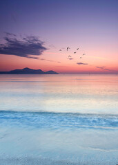 Endless Mediterranean Beach Bathed in Vibrant Summer Sunrise Colors