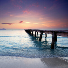 Sun-Kissed Wooden Pier Stretching Into the Vibrant Mediterranean at Dawn