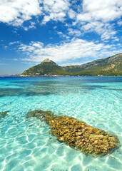 Tranquil Mediterranean Beach with Crystal Clear Blue Water Under the Summer Sun