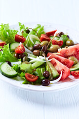 Healthy and tasty salad with , various tomatoes, olives, cucumber, onion and lettuce.	