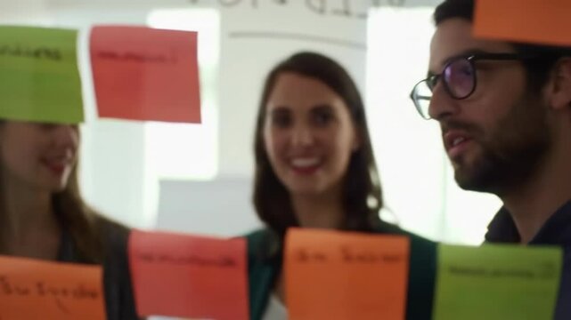 Business team brainstorming ideas on sticky notes.  Colleagues collaborate on project planning, using colorful notes for creative solutions.