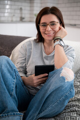 Girl Reading E-Book At Home And Looking Into The Camera