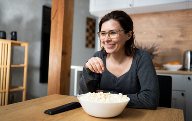 Girl Laughing And Eating Popcorn While Watching A Movie On Tv At Home