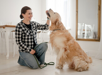Cute Girl Petting Adorable Golden Retriever Dog On The Kitchen Floor