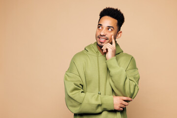 Young man of African American ethnicity wear green hoodie casual clothes put hand prop up on chin,...