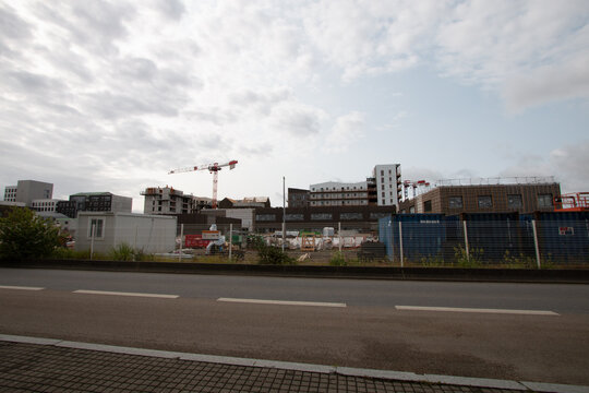 Grue &agrave; tour rouge et blanche sur le chantier de construction d'un immeuble en b&eacute;ton