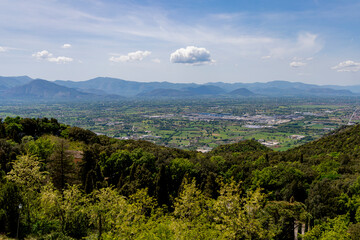 Fototapeta premium A breathtaking aerial view of Cassino, Italy, surrounded by verdant hills and distant mountains under a clear blue sky