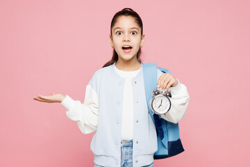 Young shocked school girl 8-9 years old wears blue casual clothes backpack hold books hold in hands...