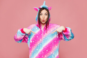 Young shocked surprised woman she wears domestic costume with hoody and animal ears point index...