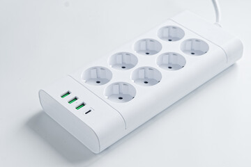 A modern white power strip with eight euro sockets and integrated USB-A and USB-C ports on a clean...
