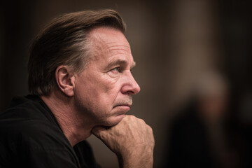 Fototapeta premium detective deep in thought portrayed on left side of frame with tense expression