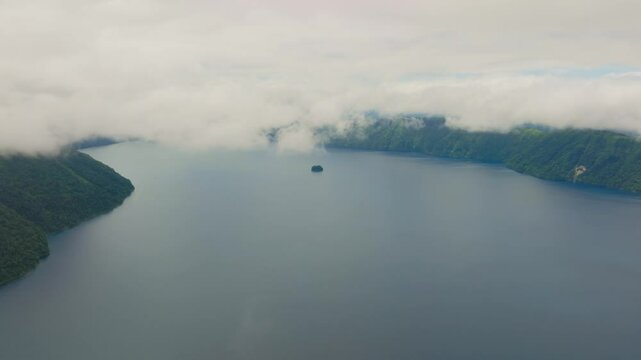 Aerial slow motion fly at Lake Mashu's Surrounding Forested Landscape, Japan Hokkaido famous volcanic crater